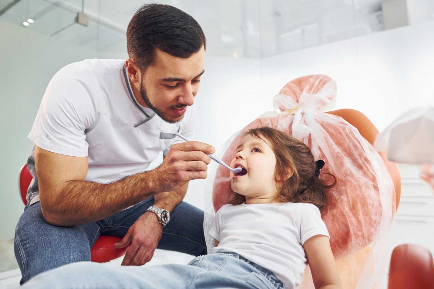 Little girl visiting male dentist in clinic conception of stomatology