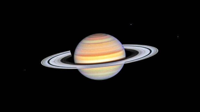 Planet Saturn with bright white rings, multi-colored main sphere, and moons Mimas, Dione, and Enceladus