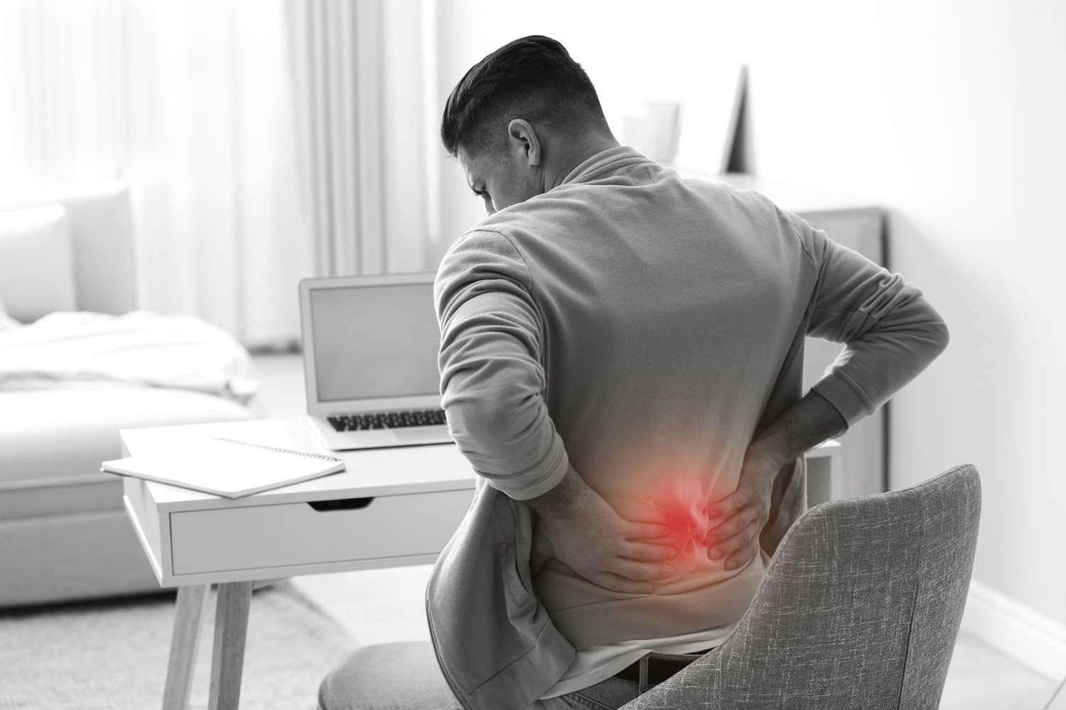 Man suffering from back pain at workplace bad posture problem