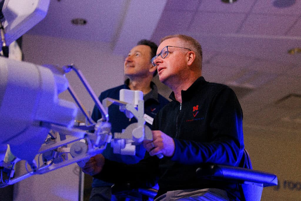 Nebraska Engineering professor and Virtual Incision co-founder Shane Farritor takes a turn using the surgical robot as Dr. Dmitry Oleynikov watches. 
