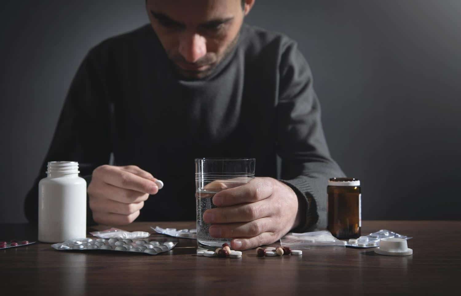 Caucasian depressed man with a pills.