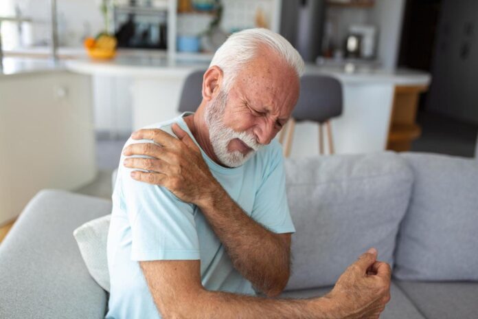 Image showing Senior elderly man touching his shoulder suffering from shoulder pain sciatica sedentary lifestyle concept shoulder health problems Healthcare insurance