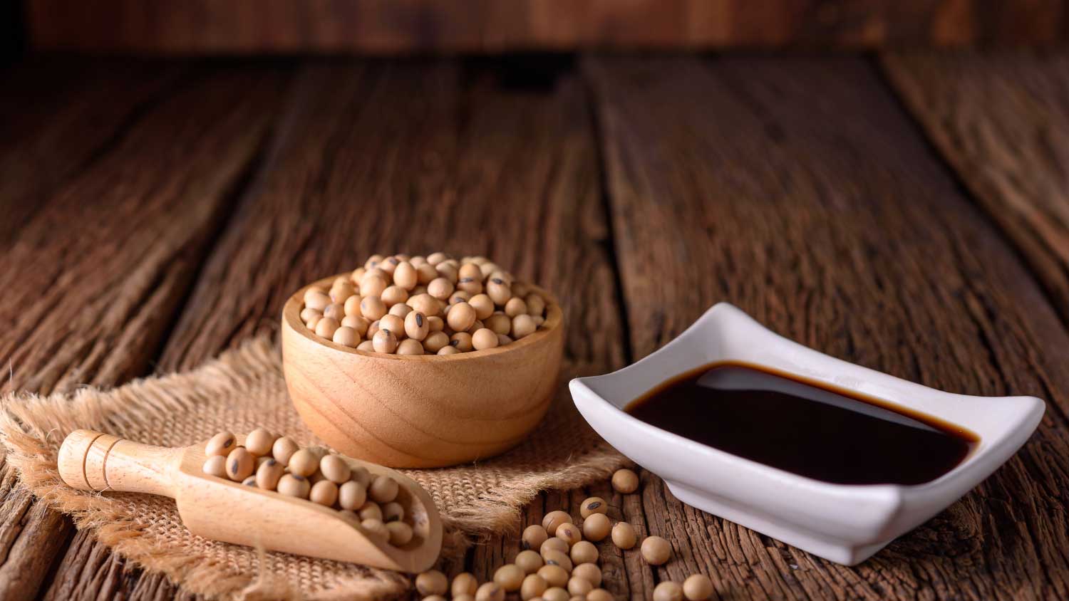 Soy sauce with soy bean on wooden background