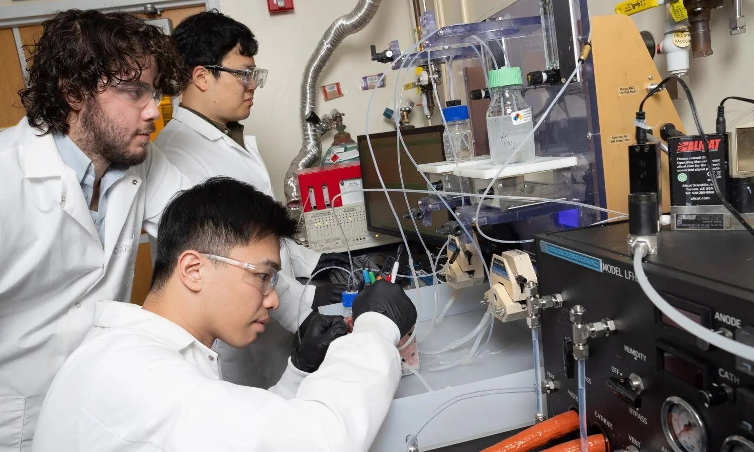 A new electrochemical reactor design developed with Marta Hatzell by postdoctoral scholar Hakhyeon Song (middle) and Ph.D. students Carlos Fernández and Po-Wei Huang (seated) converts carbon dioxide removed from the air into useful raw material.