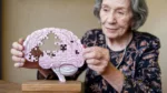 dementia risk world Mixed ethnicity elderly woman holding brain shaped puzzle